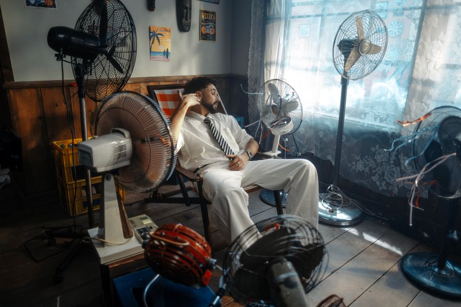 Hombre con traje blanco y ventiladores retro